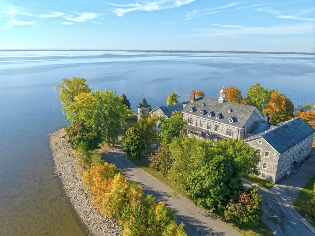Manoir patrimonial en bord de fleuve photographié par drone à l'automne