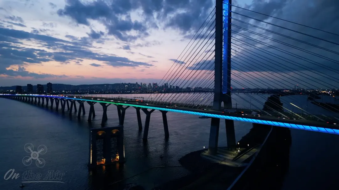 Pont Samuel-De Champlain illuminé au crépuscule, avec le centre-ville de Montréal en arrière-plan